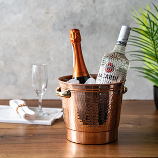 Handcrafted hammered copper ice bucket with brass handles, designed for chilling wine, champagne, beer, and cocktail ice. Stylish and durable, perfect for home bars and entertaining.
