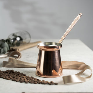 Handmade copper Turkish coffee pot (cezve) with a tin-lined interior and ergonomic handle, designed for brewing authentic Turkish, Arabic, and Greek coffee.