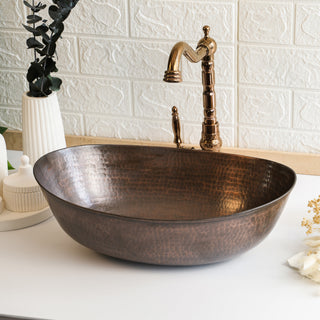 Transform your bathroom or kitchen with this Handmade Hammered Copper Oval Sink Basin, a luxurious blend of style and craftsmanship. Crafted by skilled artisans, this 100% pure copper basin features a stunning hammered texture, bringing warmth and character to your decor. Its rich, antique finish makes it a striking centerpiece, while its oval shape ensures a sleek, modern touch to elevate any vanity or countertop.