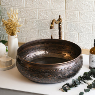 Handmade 16" dark copper round vessel sink with engraved detailing and a hammered finish, ideal for bathroom or kitchen installations.