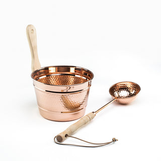 Hand-hammered copper sauna bucket with a wooden handle and matching copper ladle, designed for sauna use with a 5L capacity and elegant craftsmanship.