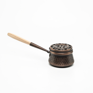 Handcrafted hammered copper incense burner with a dark copper finish, ventilated lid, and wooden handle, designed for incense cones or resin incense.