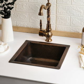 Handmade hammered copper undermount kitchen sink with a rustic farmhouse design, 18" x 18" dimensions, and an included drain cap for seamless installation.