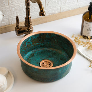 Handmade green patina copper sink with a hammered finish, round shape, and durable construction, ideal for farmhouse-style kitchens, bathrooms, or commercial spaces.