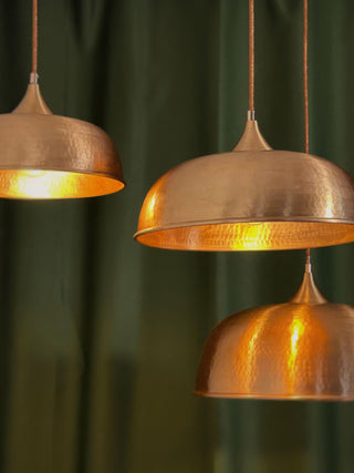 Handmade matte copper pendant light with a hammered finish, available in 12", 14", and 16" sizes, includes solid copper fittings and a textile cord for easy installation.