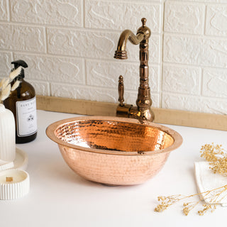 Handmade oval copper drop-in sink with a hammered finish, available in dark and pure copper, featuring a rustic design and included drain cap, perfect for kitchen or bathroom use.