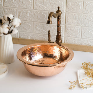 Close-up of the dark copper sink's hand-hammered texture, showcasing unique artisanal craftsmanship.
